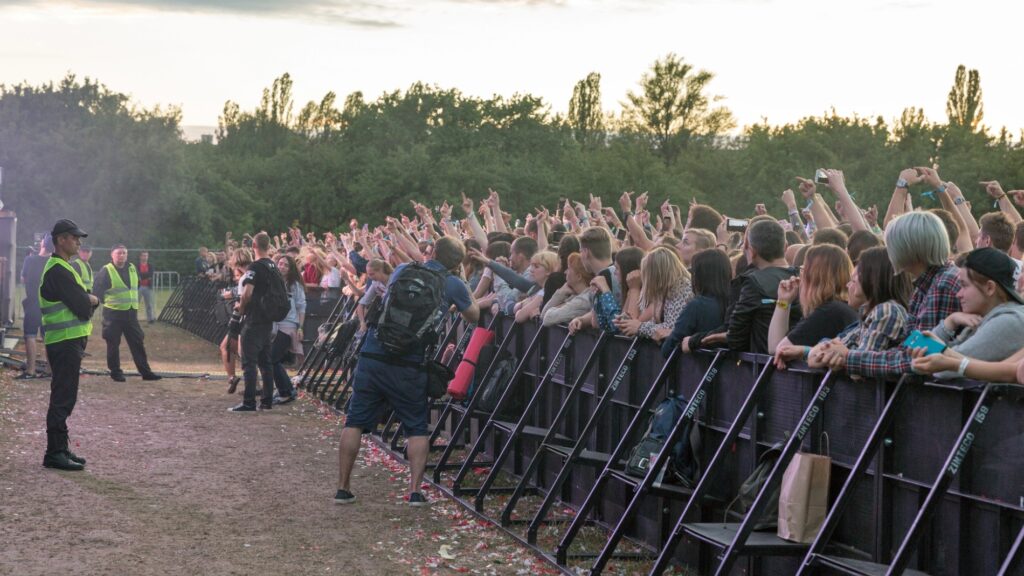 Zaštitari ispred publike na rock koncertu uz ogradu i photo pit
