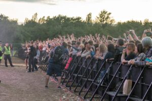 Zaštitari ispred publike na rock koncertu uz ogradu i photo pit