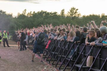 Zaštitari ispred publike na rock koncertu uz ogradu i photo pit