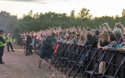 Zaštitari ispred publike na rock koncertu uz ogradu i photo pit